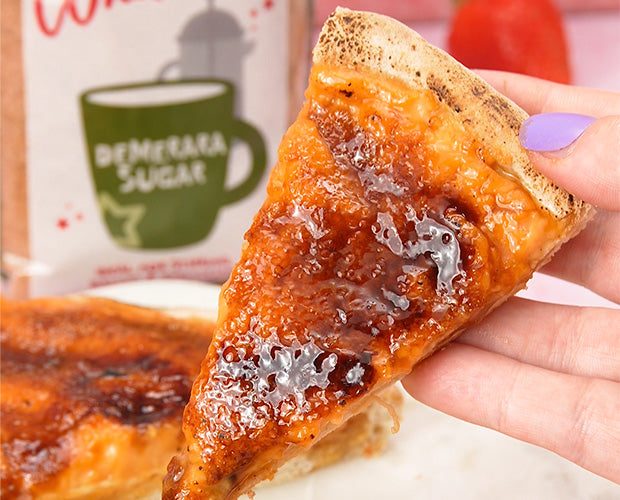 Slice of sweet pizza topped with a creme brulee topping and caramelised demerara sugar