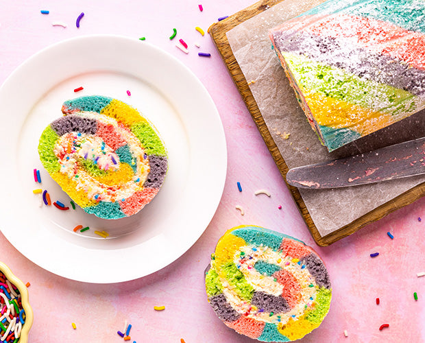 Slices of rainbow swiss roll made with coloured sponge cake 