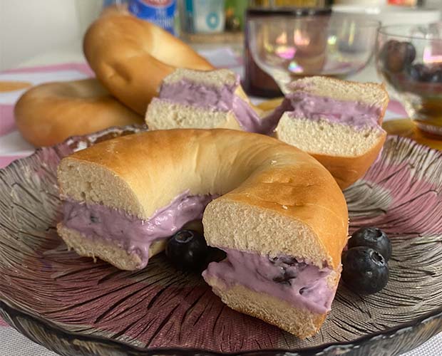 Bagel cut into two and filled with creamy blueberry filling