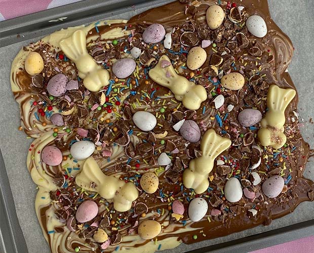 A large sheet of white and milk cholate melted together and cooled decorated with Easter chocolates