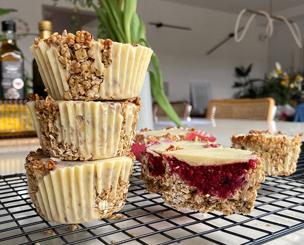 Raspberry filled cups made from oats topped with white chocolate 