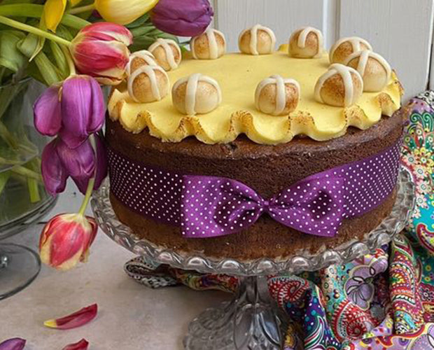 Large hot cross bun Simnel cake wrapped with a purple bow
