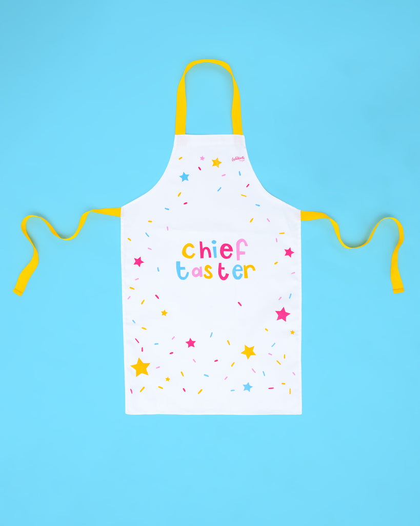 Flat lay image of Whitworths Chief Taster white kids apron decorated with colourful stars 