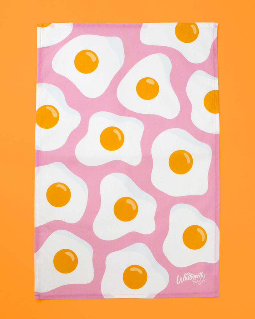 flat lay of tea towel printed with pink fried egg design