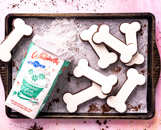Chocolate biscuits cut in shape of a dog bone, layered with white fondant icing