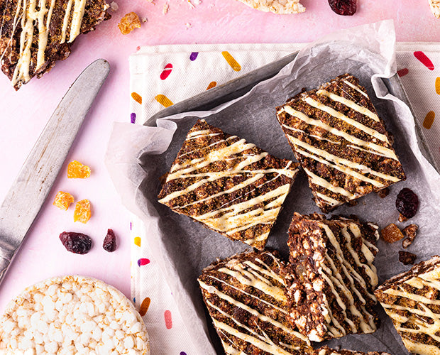 Square slices of rice cake bars topped with white chocolate drizzle