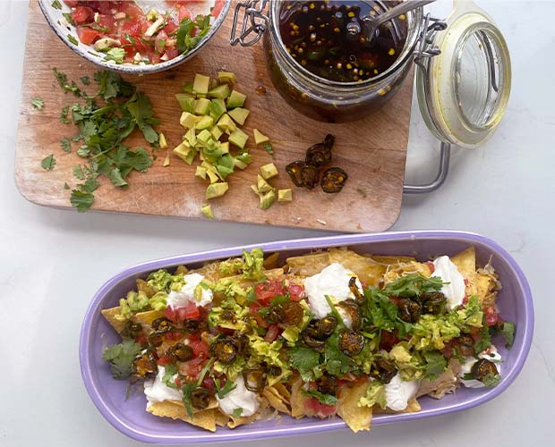 Candied Jalapeños over cheesy nachos with salsa and guacamole