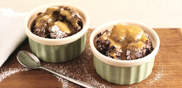 Two chocolate puddings topped with toffee sauce 