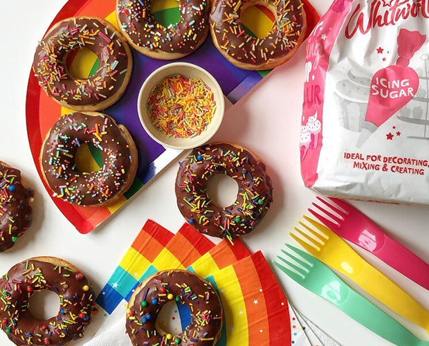 Some chocolate doughnuts topped with sprinkles 