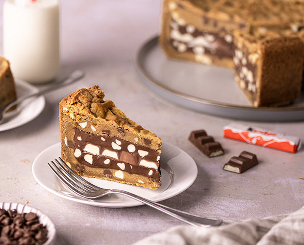 a slice of chocolate cookie dough pie, filled with kinder chocolate filling 