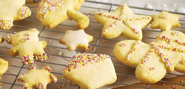 golden cookies sprinkled with sprinkles drying on a tray