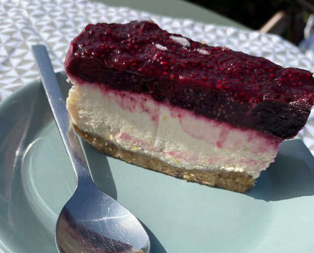 a slice of a vegan and gluten free cheesecake topped with cherries