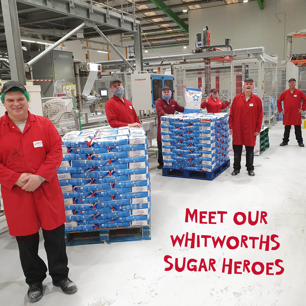 Picture of the Whitworths team posing in the factory next to sugar 