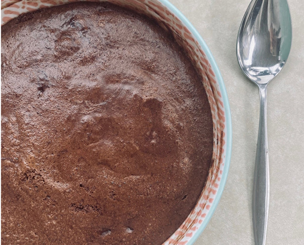 A large bowl of chocolate mousse with a serving spoon